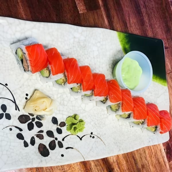 My Sushi & Catering LLC's salmon sushi roll with avocado, ginger, wasabi, and a side of green sauce.