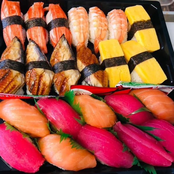 A sushi platter with various nigiri, including crab, shrimp, eel, egg, salmon, and tuna.